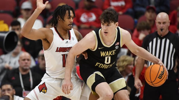 Dec 29, 2021; Louisville, Kentucky, USA; Wake Forest Demon Deacons forward Jake LaRavia (0) dribbles against Louisville Cardinals guard Dre Davis (14) during the second half at KFC Yum! Center. Louisville defeated Wake Forest 73-69. Mandatory Credit: Jamie Rhodes-USA TODAY Sports